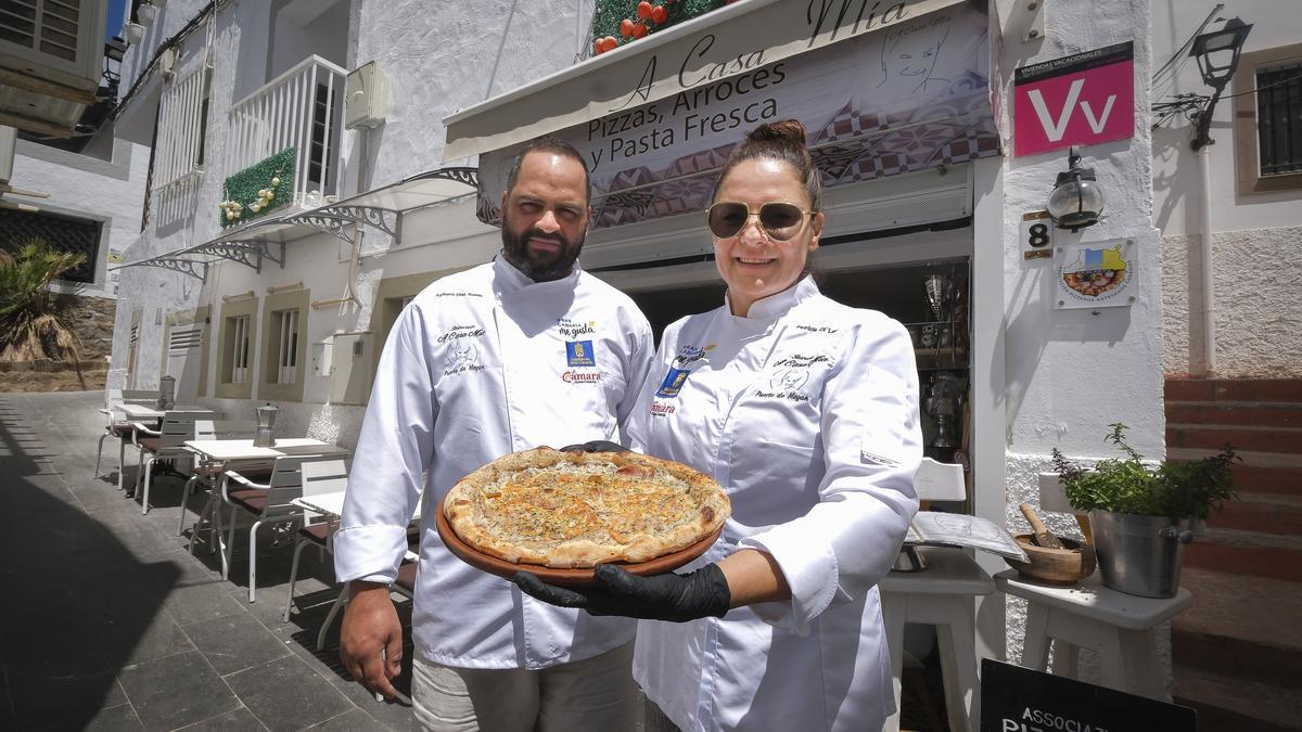 Patrizia di Leo y Aythami Díaz muestran la pizza ‘La Guapa’ a las puertas de su local en el callejón Las Conchas de Playa de Mogán.