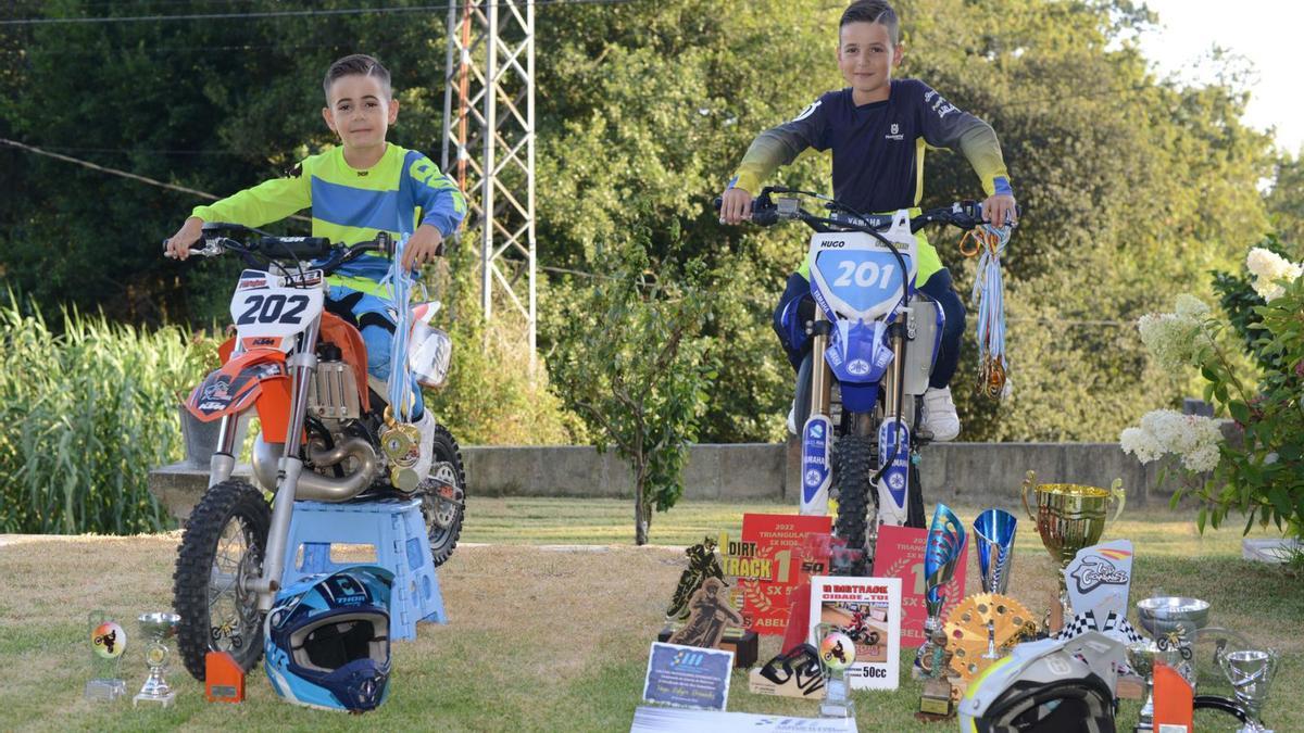 Noel (izqda.) y Hugo, 
con sus motos y sus 
trofeos, en el jardín de 
la casa de sus abuelos,
en Aldán.   | // GONZALO NÚÑEZ