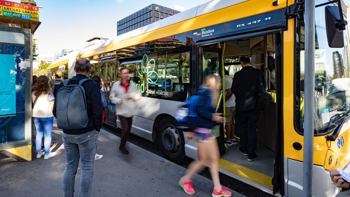Viajeros a punto de subir en un autobús metropolitano híbrido de gestión indirecta