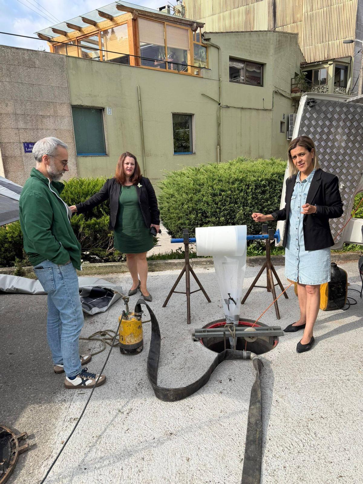 La alcaldesa Araceli Gestido (centro) con los ediles Antón Iglesias y Sagrario Martínez, ayer, en las obras de renovación del colector en Aldán.