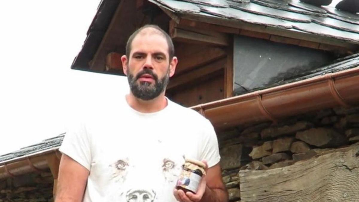 El apicultor Alberto Uría, con uno de sus tarros de miel.