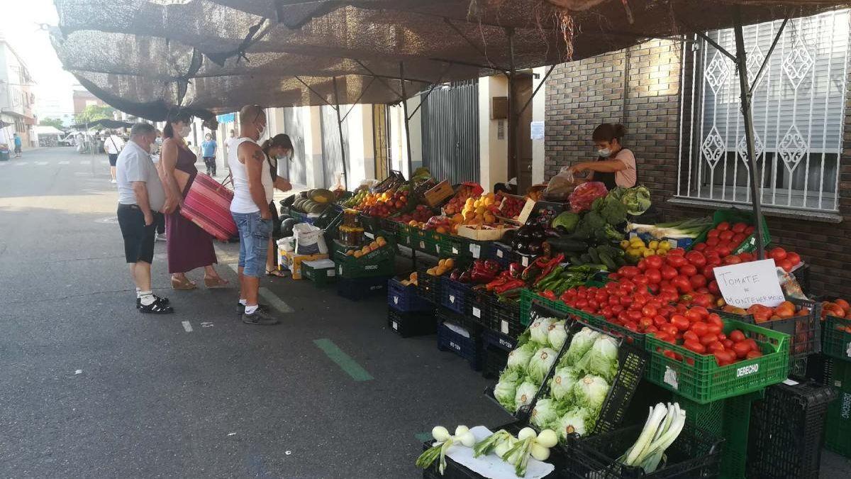 Varias personas compran en un puesto de alimentación durante el mercadillo semanal celebrado en Coria.