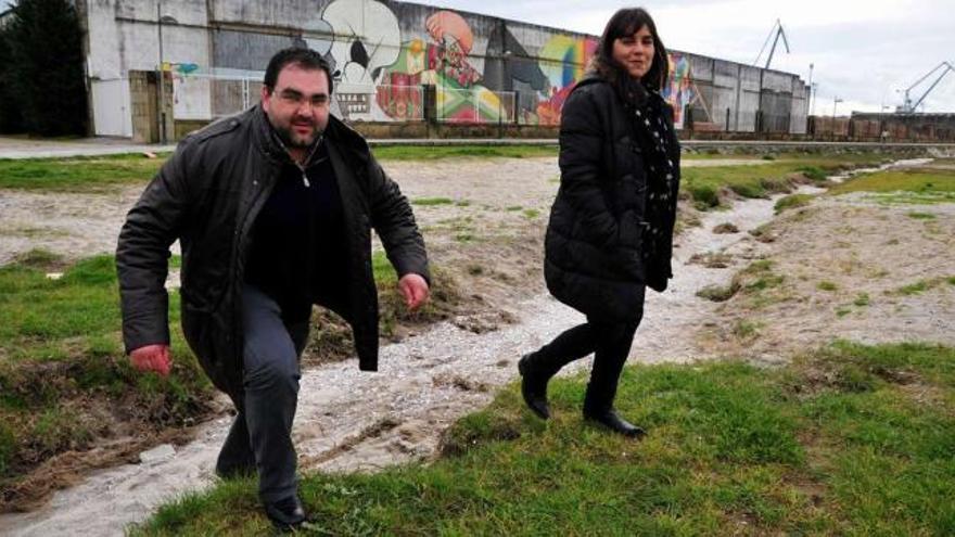 Tania García y Lino Mouriño, ayer, junto al regato de A Tripeira, que vierte aguas fecales y su emisario revienta con frecuencia.  // Iñaki Abella