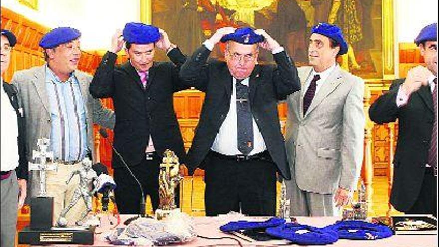 Los consejeros del Oviedo Ataúlfo Valdés y Alberto González, a la izquierda, con las boinas azules regaladas por el Ayuntamiento ovetense, junto a directivos del Caravaca.