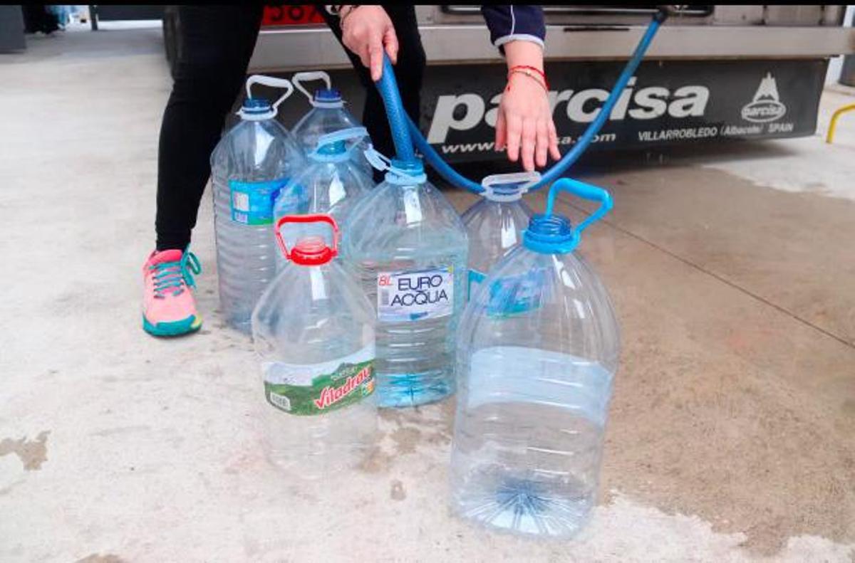 Veïns omplint garrafes d'aigua a Anglès.