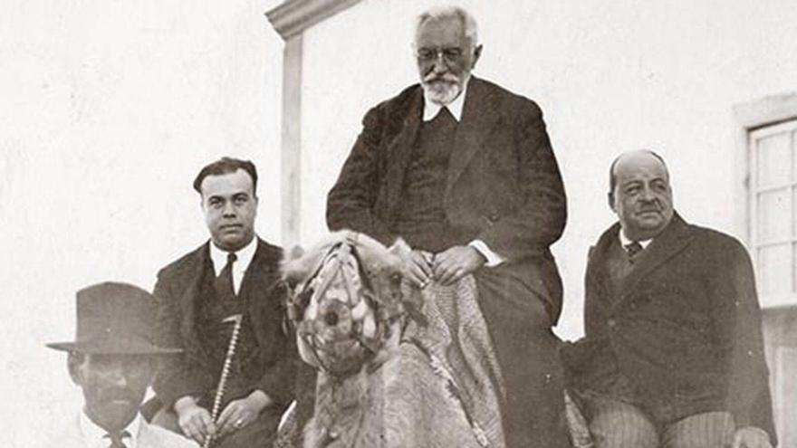 Miguel de Unamuno (centro), a lomos de un camello durante su destierro en Fuerteventura.