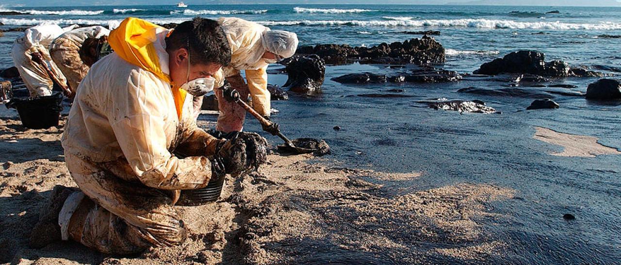 Voluntarios limpiando el chapapote en una playa. // Ricardo Grobas