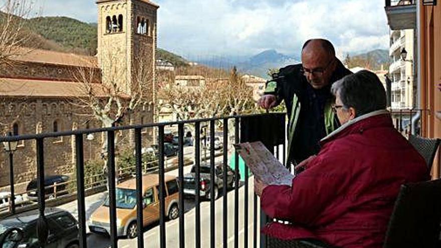 Una parella al balcó d&#039;un pis turístic a tocar de l&#039;església guardiolenca