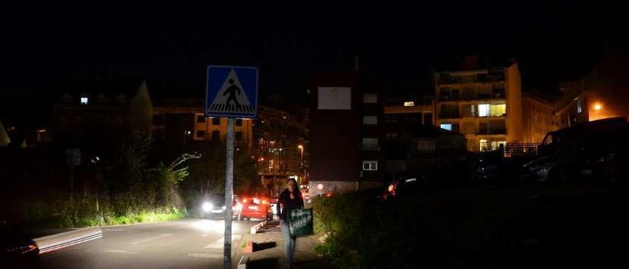 Peatones en penumbra en el tramo entre el centro de salud y el aparcamiento de Altamira. // G.Núñez