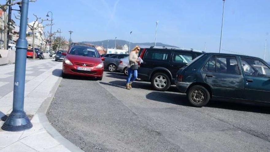 Un coche sobre la acera para circular por el aparcamiento del muelle.  // Gonzalo Núñez