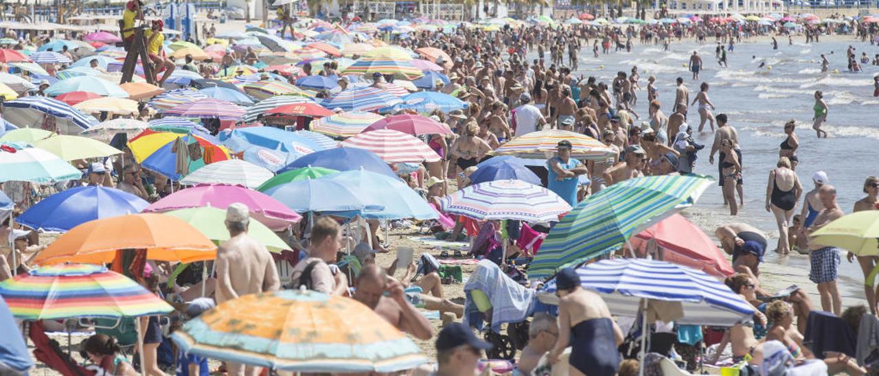 Cientos de personas disfrutan de un soleado día de playa en el Postiguet, durante el pasado verano.