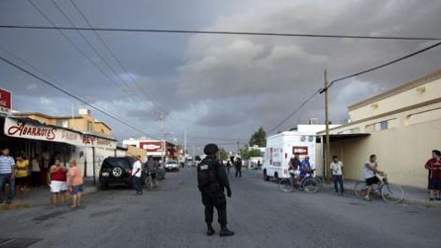 Un polícia prohibe a la gente acercarse a la escena de un crimen en Ciudad Juárez