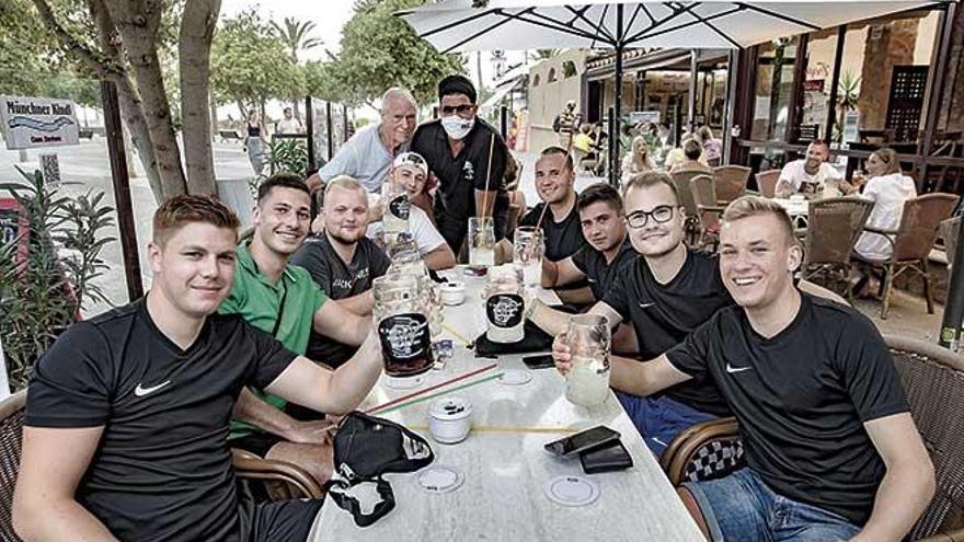 Jóvenes turistas alemanes saludan mientras toman sus bebidas.