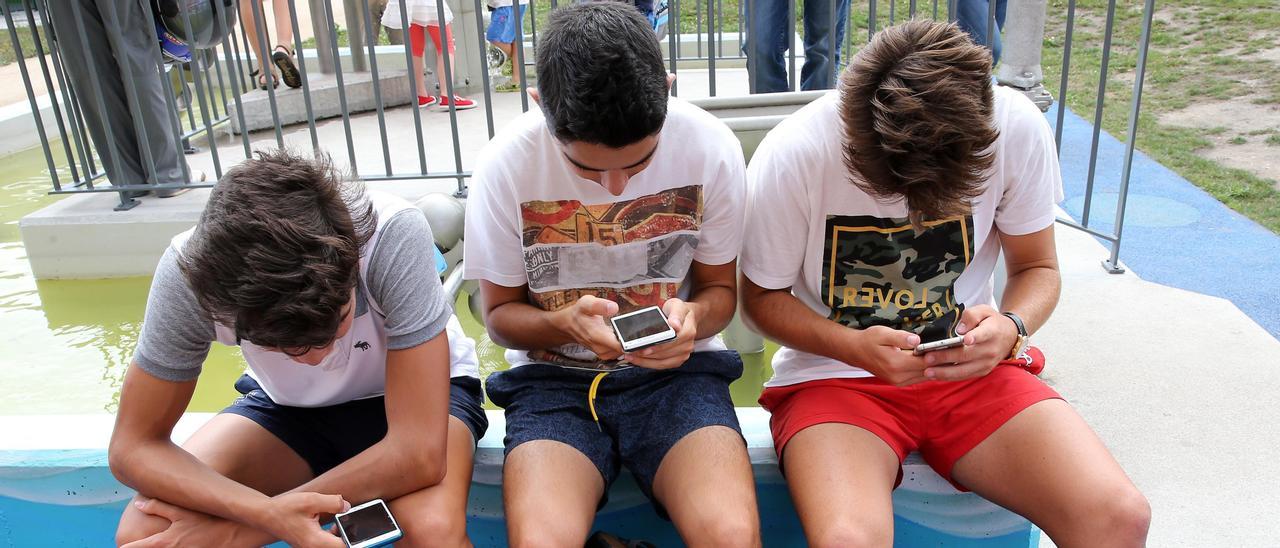 UN GRUPO DE ADOLESCENTES JUGANDO CON EL MOVIL