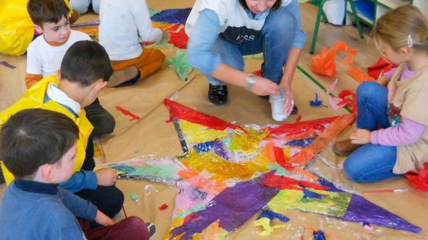 instalación navideña. La pintora riosellana Isabel García Zapatero, en la imagen, ayudando a algunos de los alumnos de cinco años que realizaron la instalación navideña.