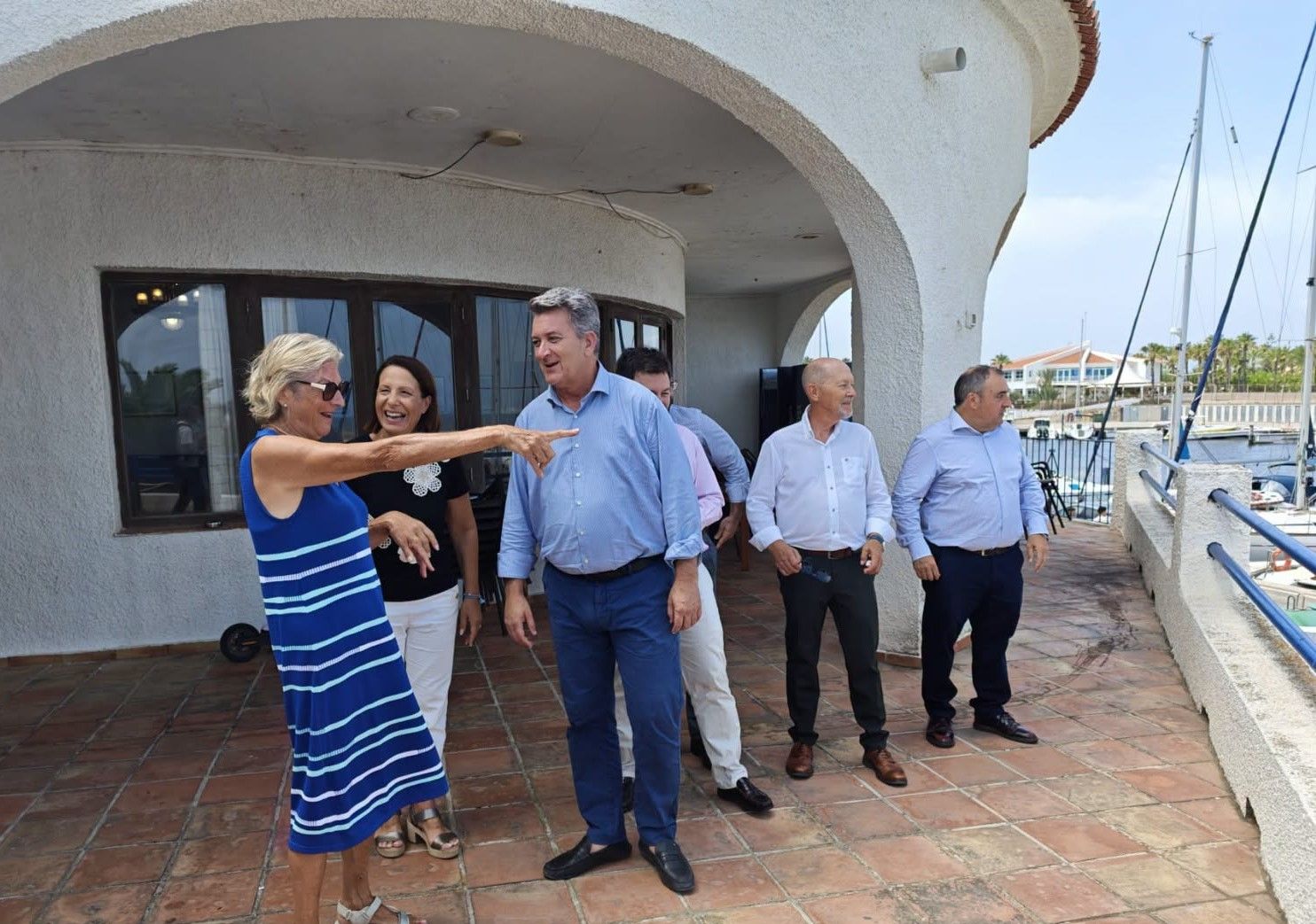 La presidenta del club, Isabel Bolinches, indica a las autoridades dónde está amarrado su barco.