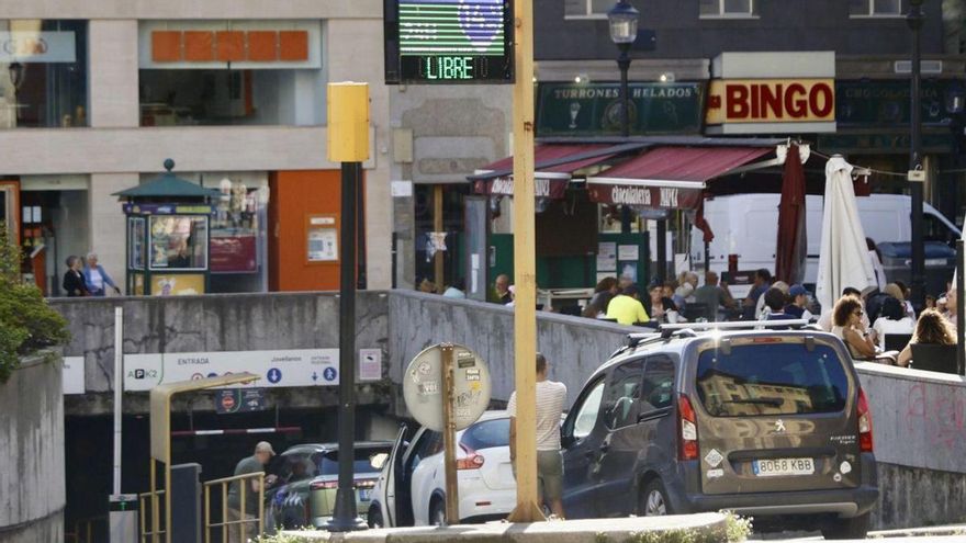 Tres coches esperando a entrar en el parking de la plaza del Seis de Agosto. | MARCOS LEÓN