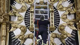 Los bomberos de Madrid cumplen con la tradición al bajar el cuadro de la Virgen de la Paloma