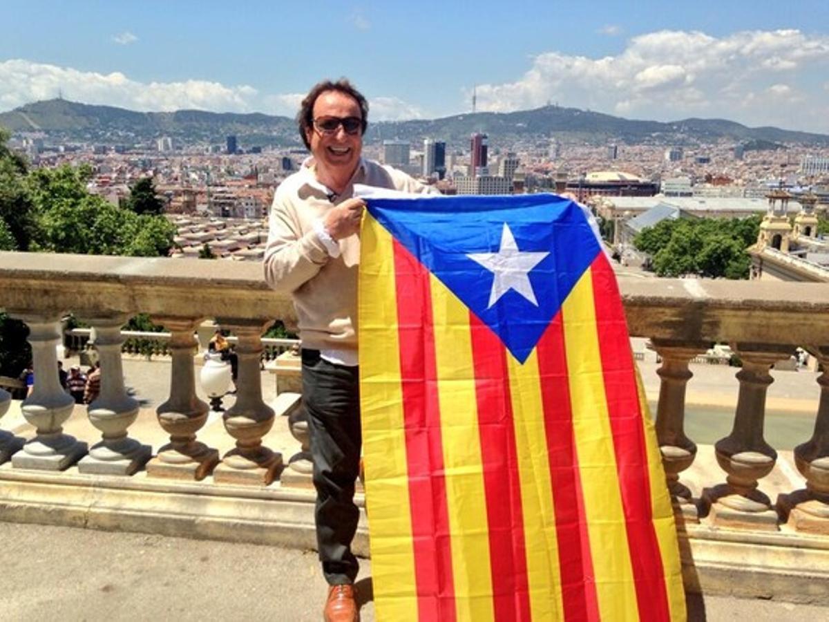 Dyango subjecta l’estelada amb la plaça d’Espanya al fons.