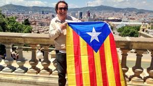 Dyango sujeta la ’estelada’ con la plaza de Espanya al fondo.