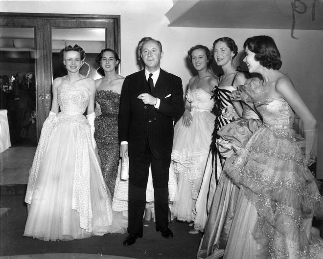 Christian Dior rodeado de modelos luciendo sus diseños