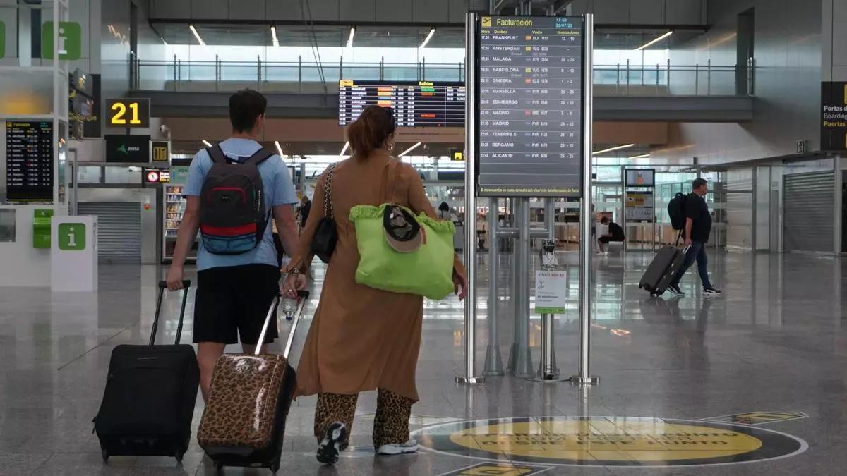Dos pasajeros se dirigen a coger un vuelo en el aeropuerto de Santiago.