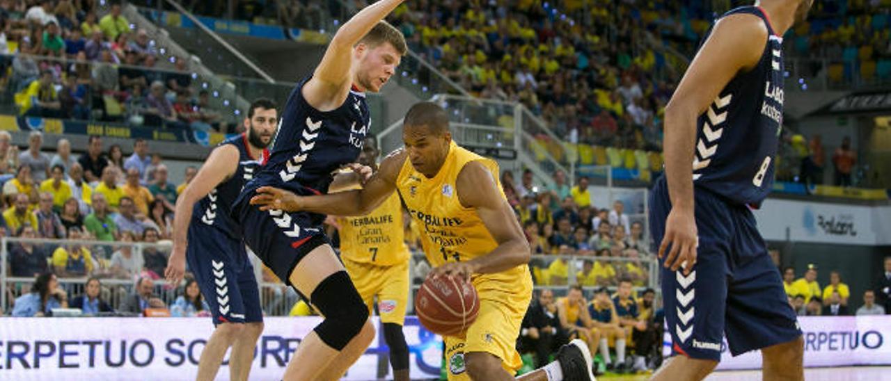 El ala-pívot dominicano Eulis Báez penetra a canasta ante la defensa del alero letón Davis Bertans.