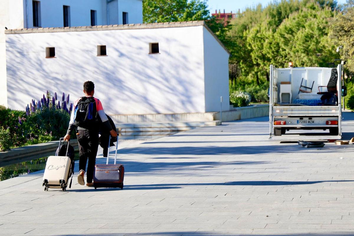 Una de las personas desalojadas abandona el lugar con sus maletas.