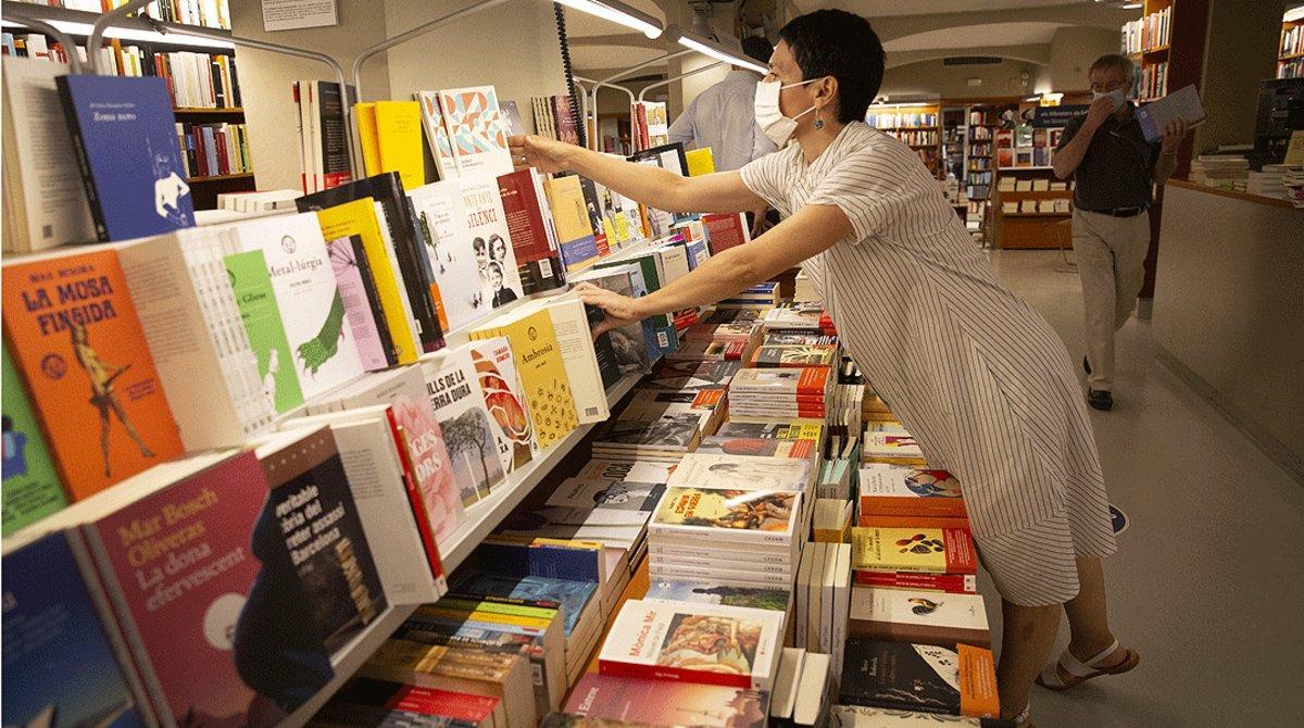 Una empleada recoloca varios libros en las estanterías de la librería Laie de Barcelona, el pasado 21 de julio.