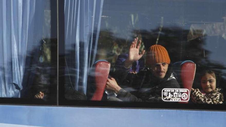 Un rebelde sirio dice adiós al dejar Homs en un autobús. // Reuters