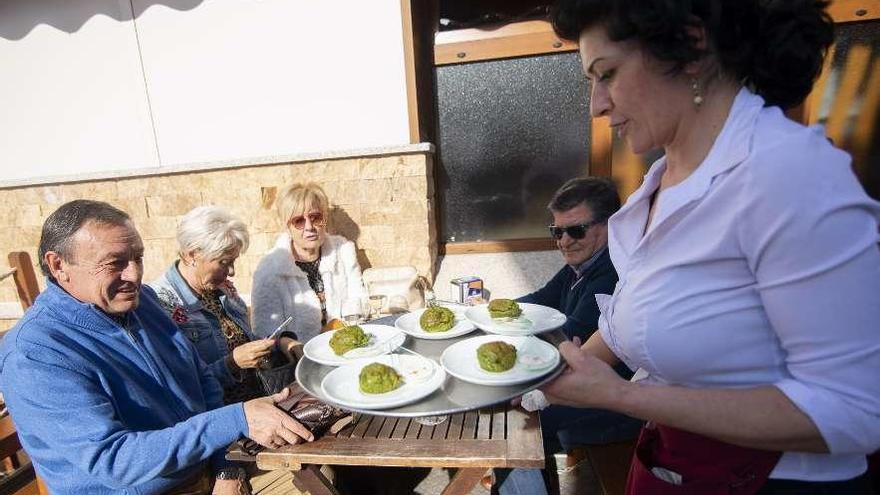 Por la izquierda, Mundo Díaz, Blanca Comonte, Charo Fernández, José María Conde y Milagros Romo, que sirve los pinchos en una terraza de un bar de San Juan de la Arena.