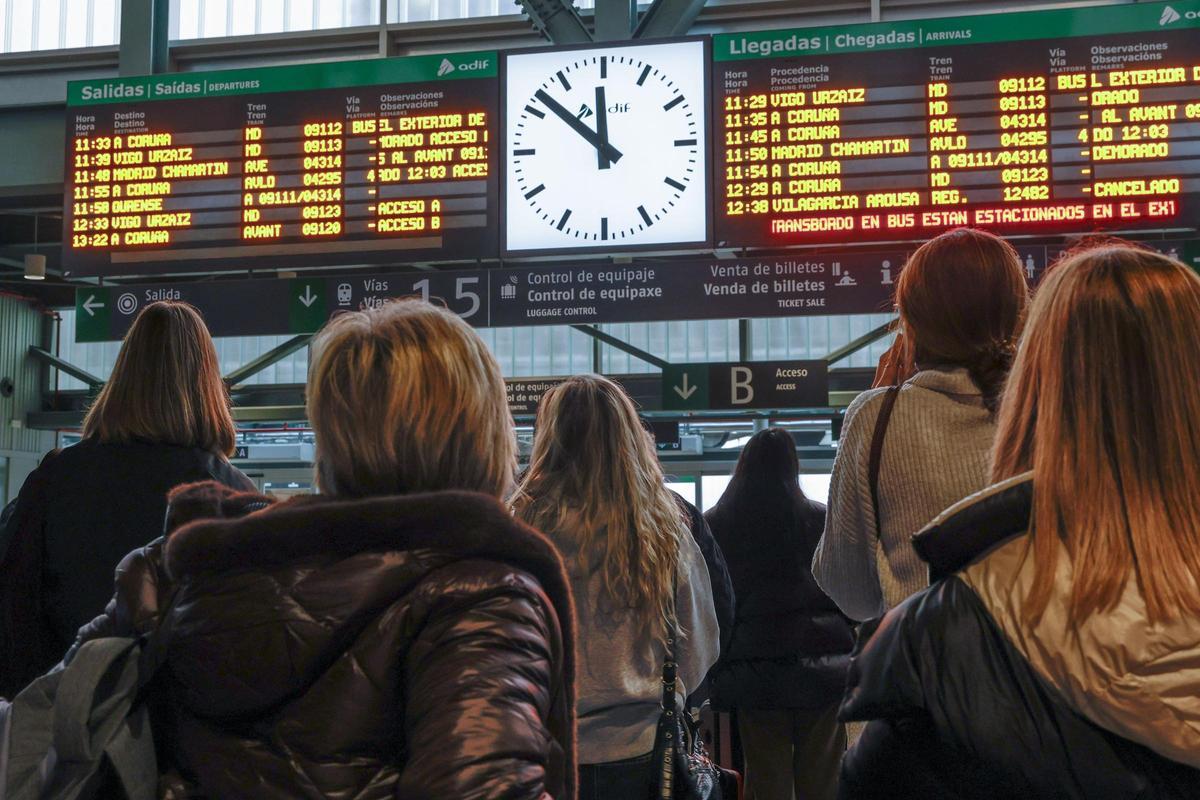 Usuarias de Renfe consultado los servicios ferroviarios en la estación de Santiago.