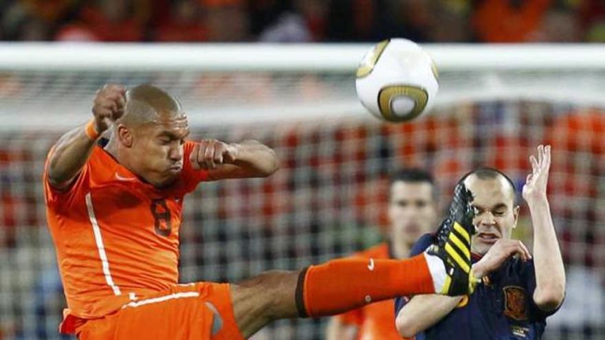 Nigel de Jong ´lucha´ por el balón con Andrés Iniesta.