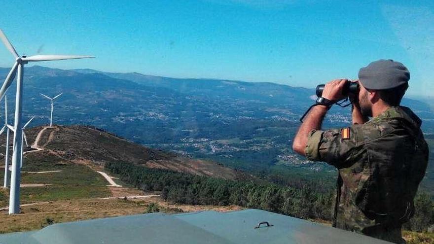 Un soldado vigila el monte desde un puesto de observación. // Brilat