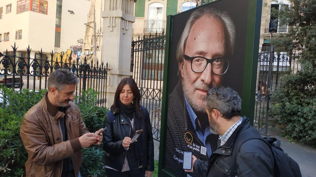 El fotógrafo Toni Miranda y los concejales de Participación Ciudadana y Cultura, Teresa Sanjuán y Raül Llopis, escaneando un código QR.