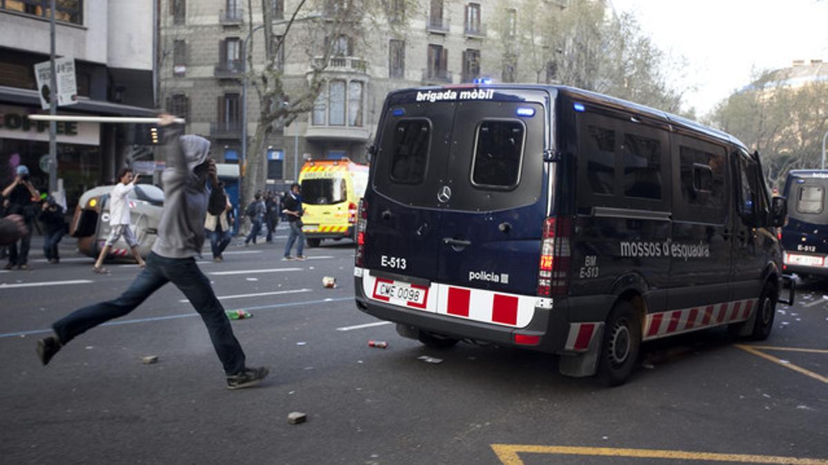 Un hombre con un palo trata de golpear un furgón de los Mossos, en Barcelona, durante la huelga general del 29-M.