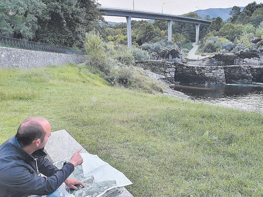 El secretario de la asociación O Trabadoiro muestra un plano junto a unas “pesqueiras” en Arbo. // D. P.