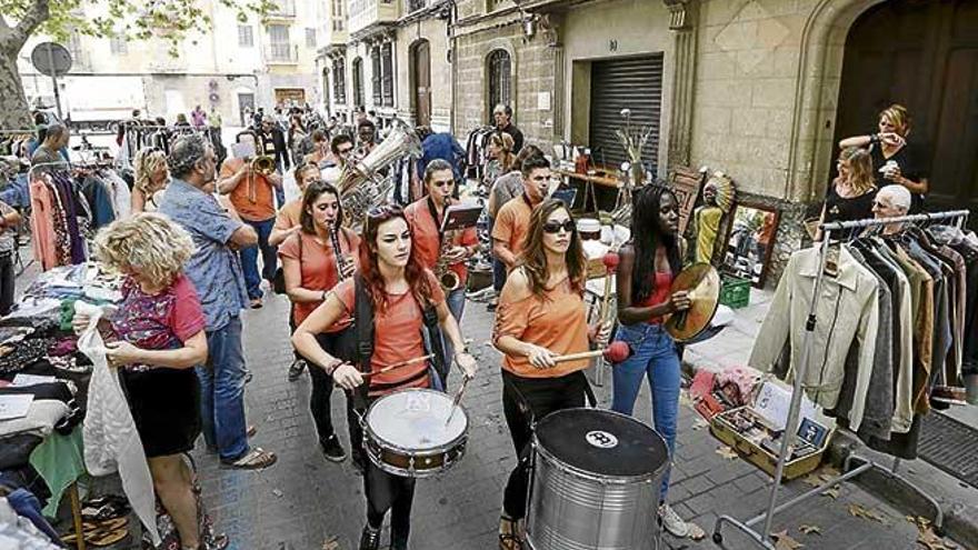 Una charanga pasa entre los puestos de ropa de la edición 2015 del mercadillo de Canamunt.