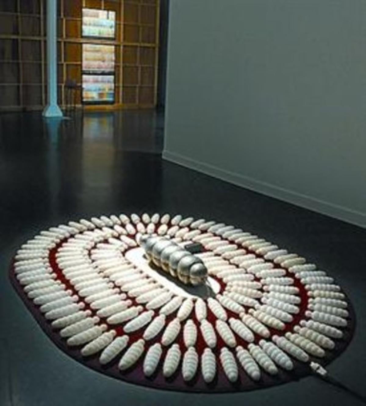 DE LA MODERNITAT A LA POSTMODERNITAT 3 En el sentit de les agulles del rellotge, obres de Jenny Olzer, Tony Cragg (i el piano i vuit cadires plenes de ganxos), Tonet Amorós (i les larves de parafina), Mike Kelley (amb la caixa-caverna de Plató), Tony Oursler (i el cap parlant) i Juan Muñoz. DE LA MODERNITAT A LA POSTMODERNITAT 3 En el sentit de les agulles del rellotge, obres de Jenny Olzer, Tony Cragg (i el piano i vuit cadires plenes de ganxos), Tonet Amorós (i les larves de parafina), Mike Kelley (amb la caixa-caverna de Plató), Tony Oursler (i el cap parlant) i Juan Muñoz.