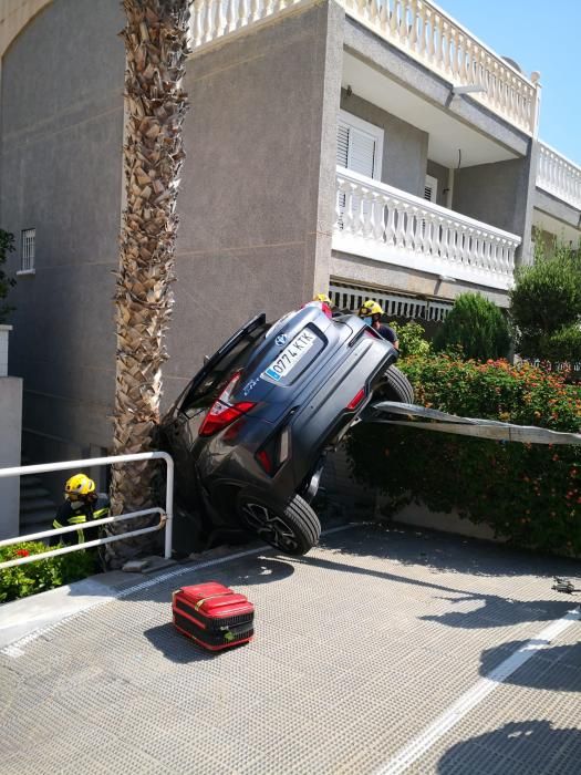 Dos ocupantes de un vehículo han sido rescatados por los bomberos de Alicante tras quedar su coche suspendido entre una palmera y una pared en el acceso de una urbanización de Alicante.