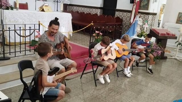 Niños de la Escuela Municipal de Música practicando con la guitarra