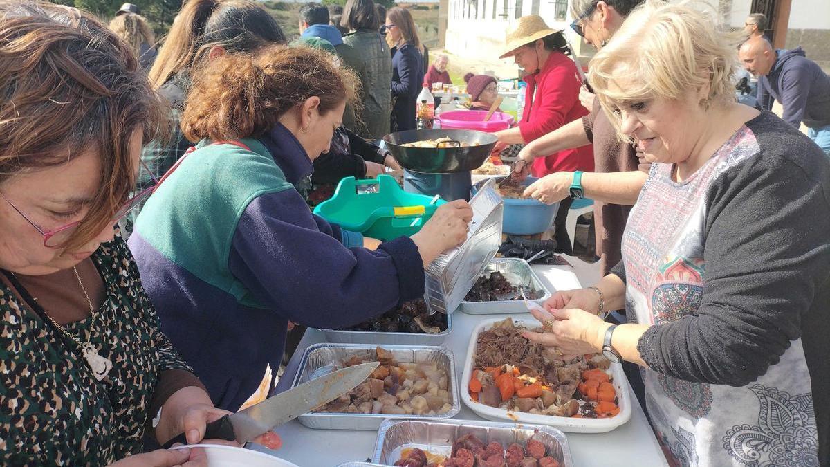 Vecinas del barrio preparan las bandejas con productos del cocido.