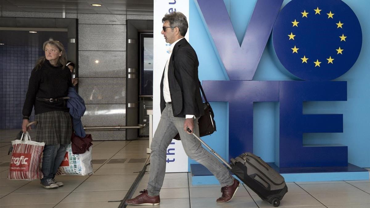 Un hombre pasa junto a un anuncio llamando al voto en las elecciones europeas en el metro de Bruselas, este viernes.