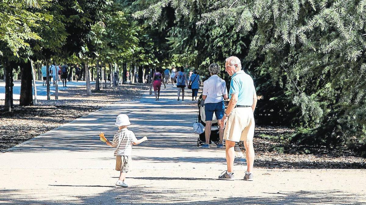 Un abuelo pasea junto a su nieto.