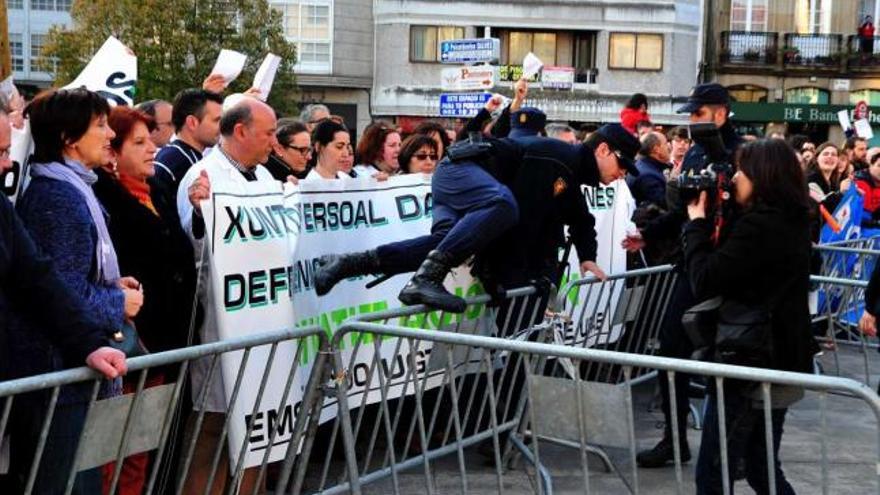 Un antidisturbios salta la valla ante la mirada de los manifestantes en la Plaza de Ravella.  // Iñaki Abella