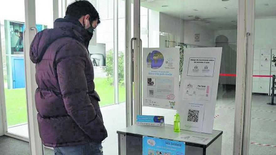 Un estudiante lee información sobre el proyecto en la entrada de la biblioteca.   | // FDV