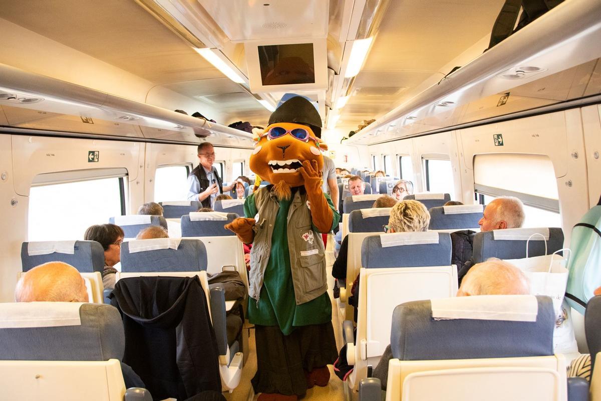 La mascota del Geoparque da la bienvenida a los pasajeros del  tren turístico de la Diputación de Cáceres y Renfe.
