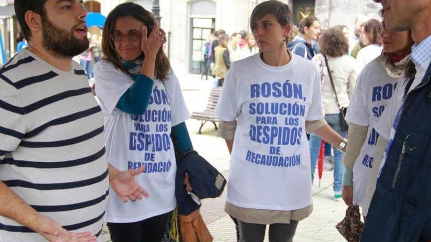 Rosón, junto a trabajadores con camisetas que protestan contra él.