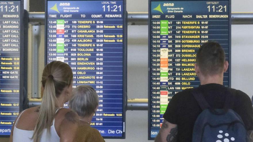 Un grupo de turistas observa las pantallas del Aeropuerto de Gran Canaria. | | J.C. GUERRA