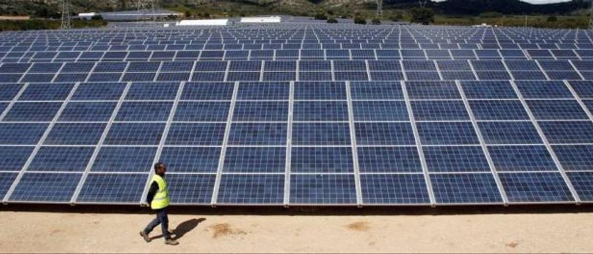 Un operario pasa ante una instalación de energía renovable en una planta fotovoltaica ubicada en la Comunitat Valenciana.